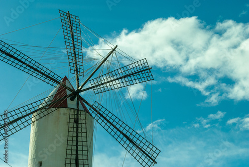 Closeup of an old vintage windmill against a blue sky on a sunny day
