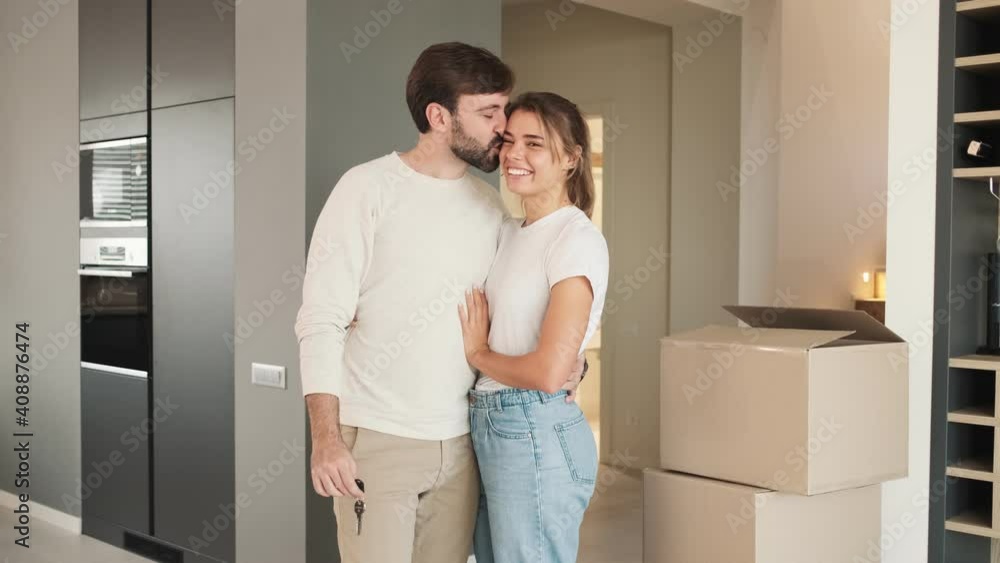 A happy couple man and woman are hugging after moving to the new flat