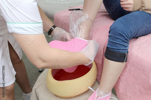 woman foot treatment in paraffin bath at the spa.
