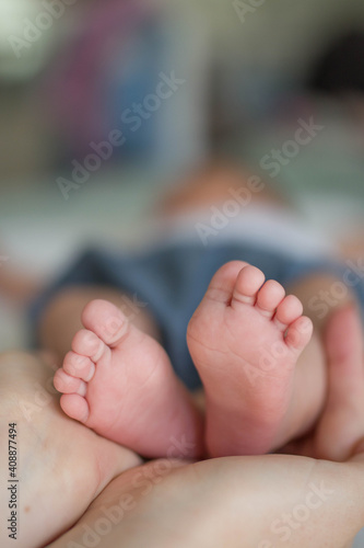 Legs of a small newborn baby in a womans hand close up