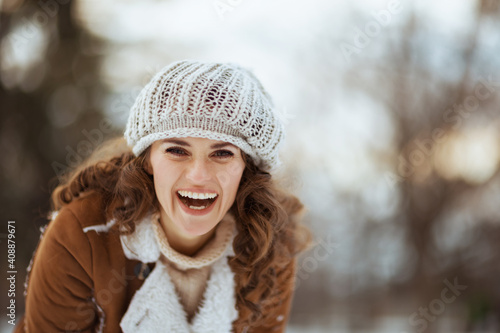 happy modern woman outdoors in city park in winter