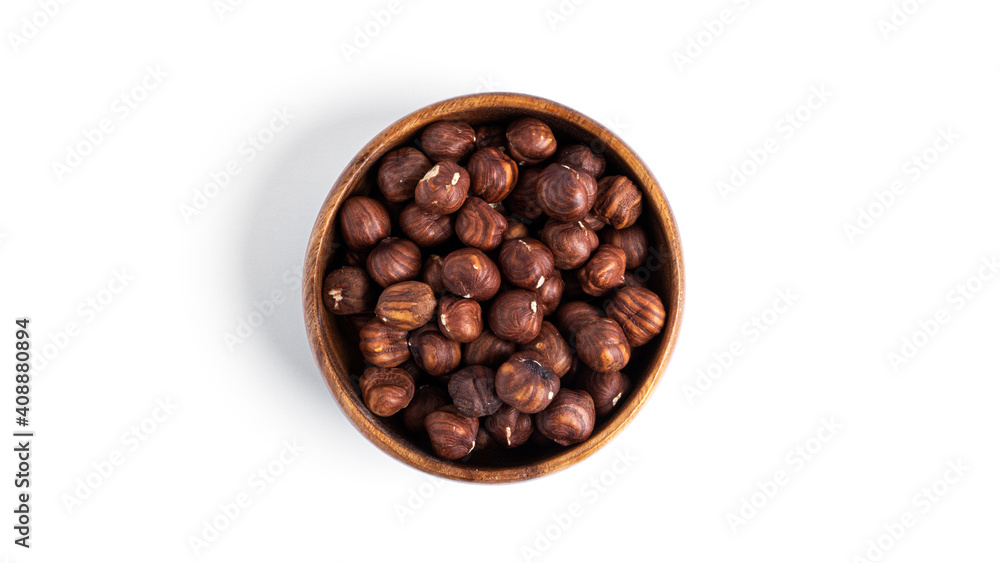 Hazelnut in a wooden bowl isolated on a white background.