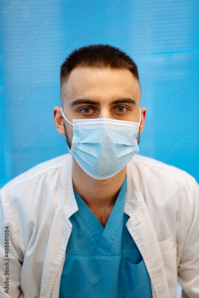 Portrait of a handsome doctor in facial medical mask. Head and shoulders portrait. Medical concept. Portrait of a handsome doctor in facial medical mask. Head and shoulders portrait. Medical concept.