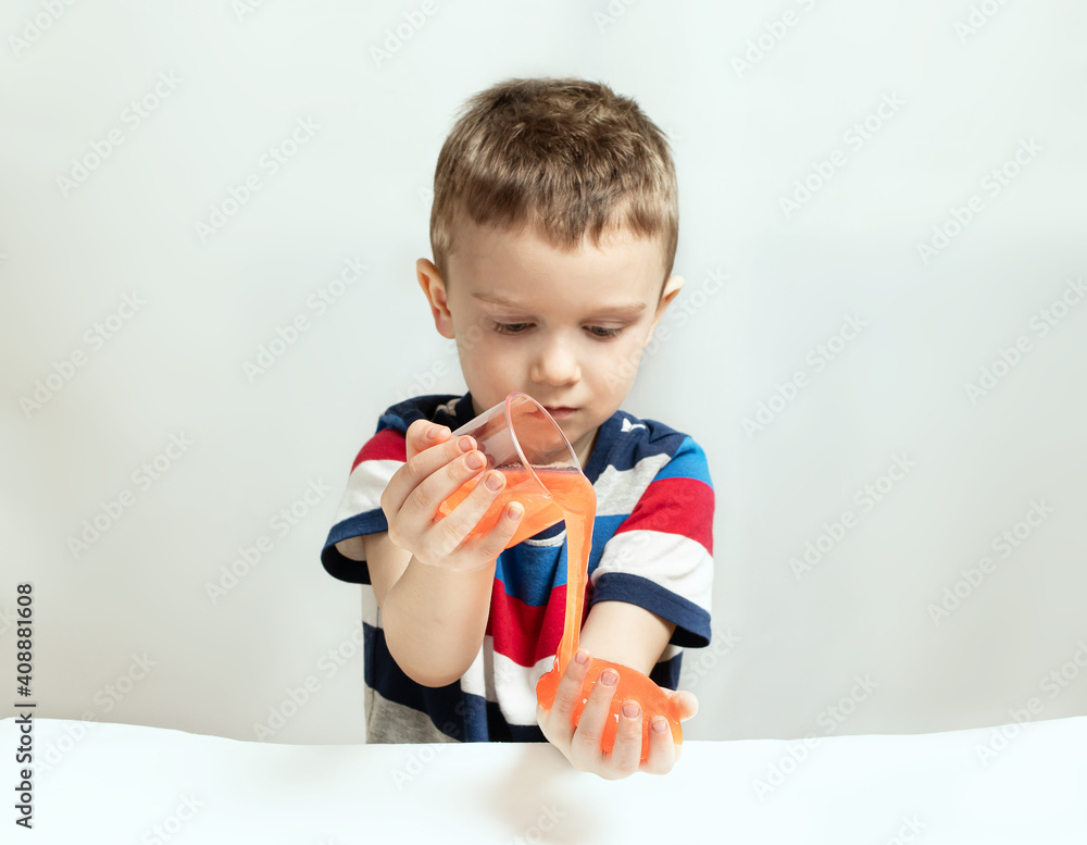 Kid playing hand made toy called slime. Kids hands playing slime toy. Making slime. Selective focus Kid playing hand made toy called slime. Kids hands playing slime toy. Making slime. Selective focus