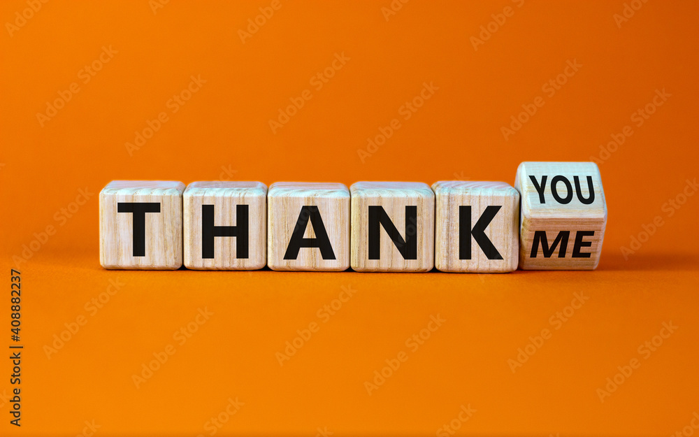 Thank you or me symbol. Turned a cube and changed words 'thank me' to 'thank you'. Beautiful orange background, copy space. Business, psychology and thank you or me concept. Thank you or me symbol. Turned a cube and changed words 'thank me' to 'thank you'. Beautiful orange background, copy space. Business, psychology and thank you or me concept.