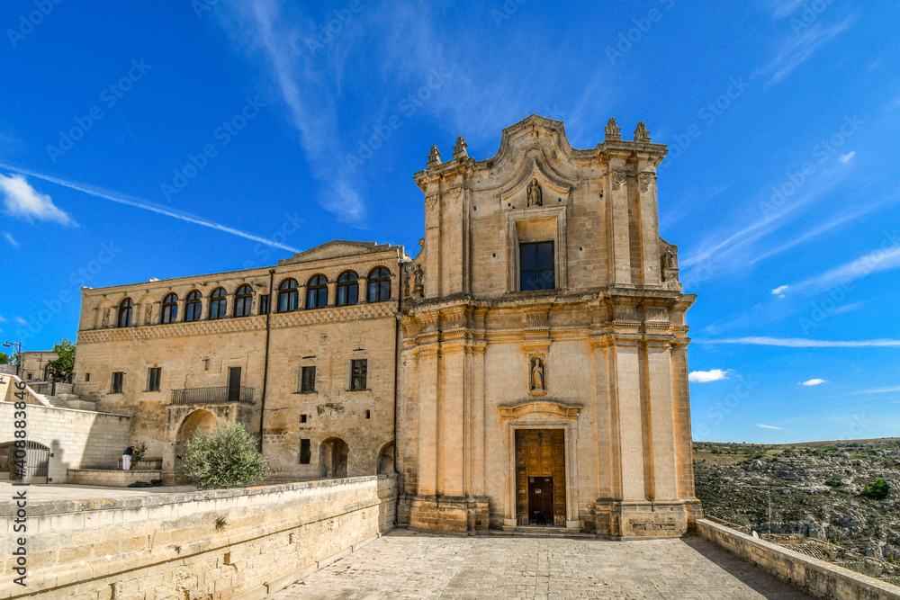 The facade of the Convent of Saint Agostino in Matera, Italy, which sits on a steep cliff overlooking a canyon ravine. An Unesco World Heritage site in the Basilicata region of Italy.