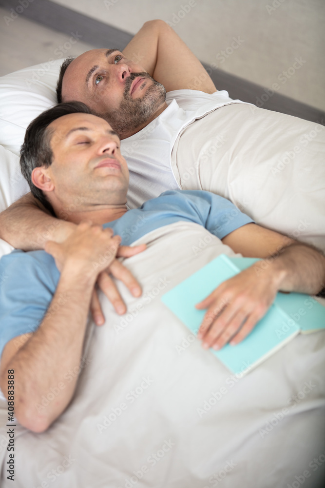 gay couple lying on bed top view gay couple lying on bed top view