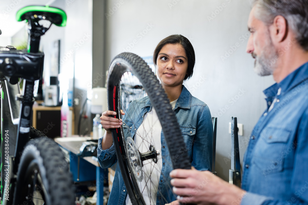 woman checking bicycle tire in shop factory woman checking bicycle tire in shop factory