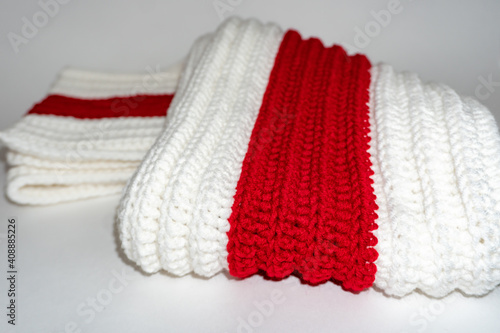 Warm knitted clothes white red white on a white background  knitted scarf