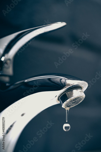 water drop dripping from the tap and water shortage 
