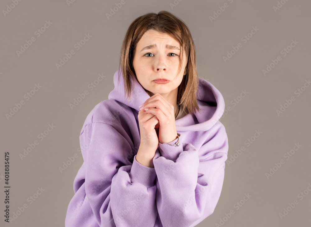 Begging. Closeup portrait sad young woman praying, hoping for the best, going through tough times i her life, isolated on gray background wall with copy space. Human emotions and facial expressions. Begging. Closeup portrait sad young woman praying, hoping for the best, going through tough times i her life, isolated on gray background wall with copy space. Human emotions and facial expressions.