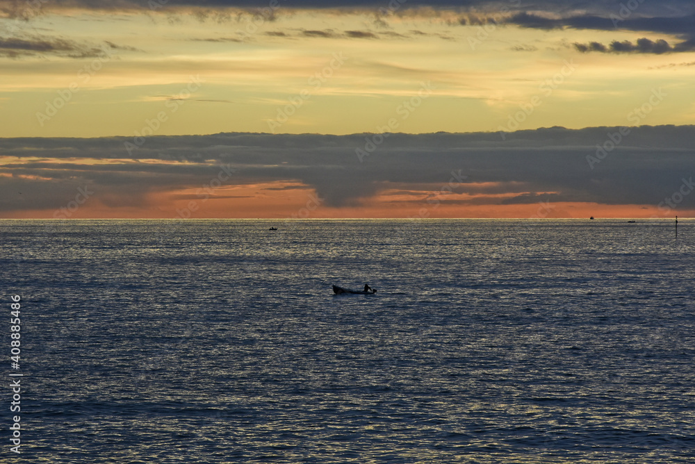 A lonely boat in the gulf of Naples at sunset time, Italy.