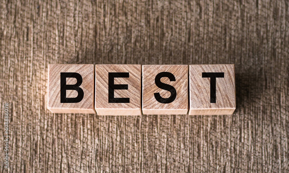 Fototapeta premium BEST word written on wooden blocks on a brown background.