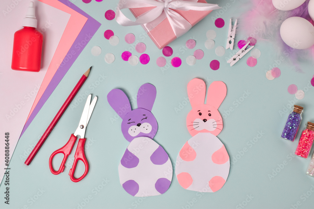 Fototapeta premium Step-by-step instructions. Easter bunnies. Step 5 The postcard is ready. DIY. Flat lay. Making an Easter card.
