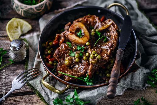 Veal ossobucco with green peas.selective focus