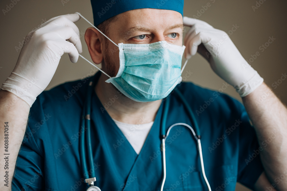 The face of a doctor in a medical mask. A surgeon in a suit. Doctor after surgery. The face of a doctor in a medical mask. A surgeon in a suit. Doctor after surgery.