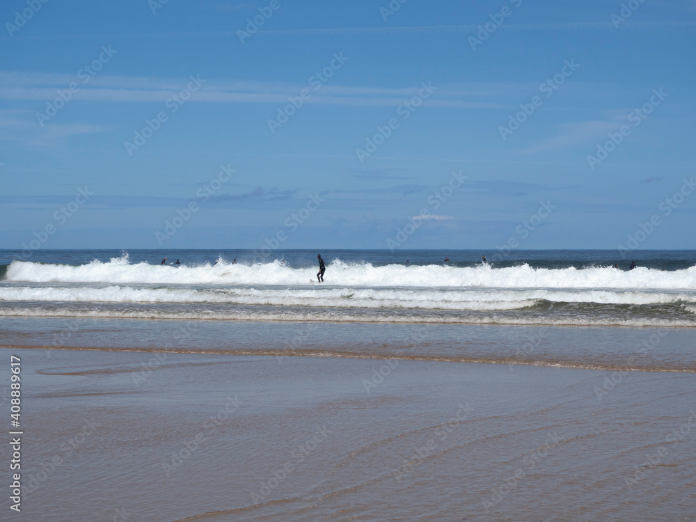 Paisaje de costa con windsurfistas sobre las olas de la Playa el Rosal en Cantabria, verano de 2020