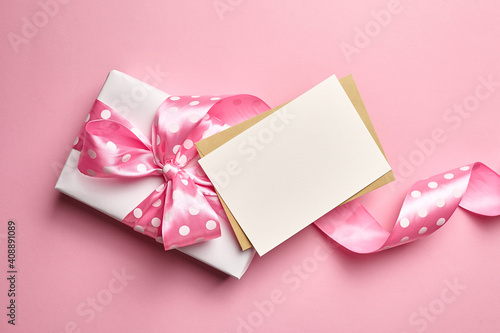 Greeting card mockup with gift box on pink background