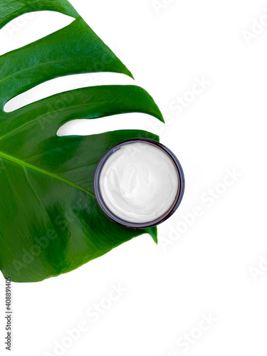 Beautiful composition with cosmetics on white background with tropical leaf, flat lay.