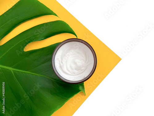 Beautiful composition with cosmetics on white background with tropical leaf, flat lay.