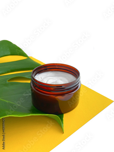 Beautiful composition with cosmetics on white background with tropical leaf.