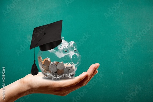 Graduation hat on a glass jar with money in hand