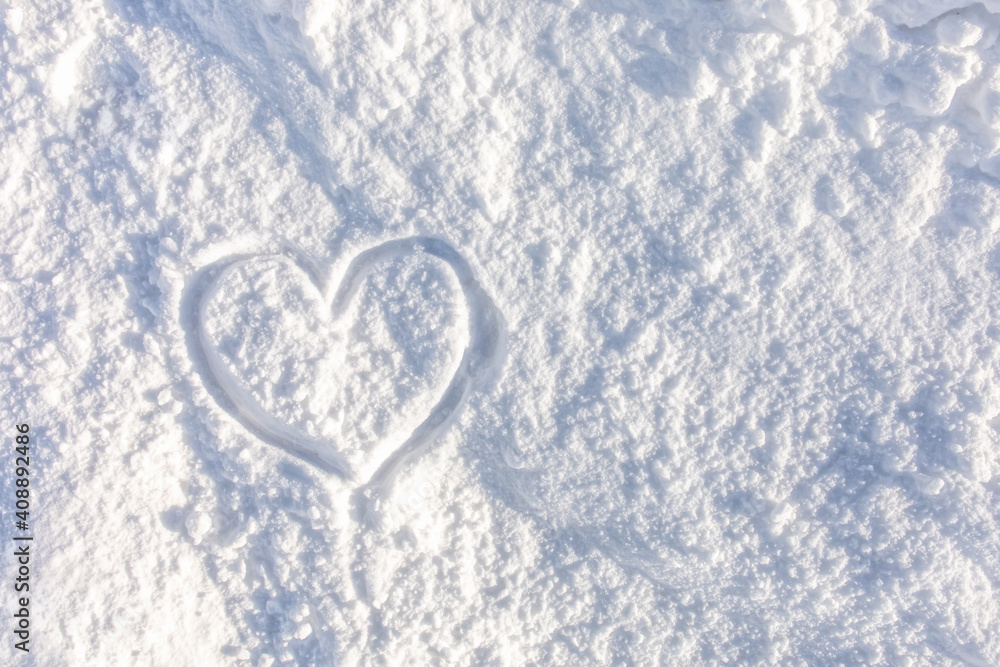 Top view, closeup hand drawn of a heart shape on pure white soft snow texture with natural sunlight in a cold weather day, a symbol of love. The romantic idea for Valentine's day with copy space. Top view, closeup hand drawn of a heart shape on pure white soft snow texture with natural sunlight in a cold weather day, a symbol of love. The romantic idea for Valentine's day with copy space.