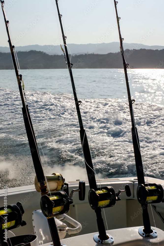 Spinning rods with reels in holders before fishing on the boat. Spinning rods with reels in holders before fishing on the boat.