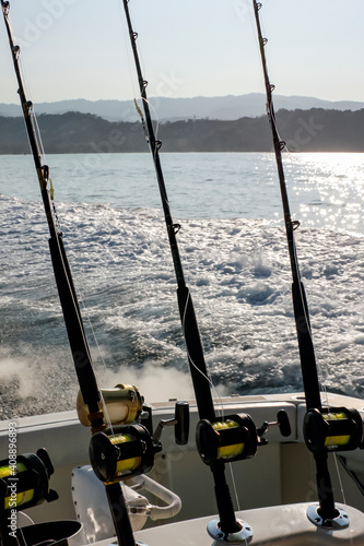 Spinning rods with reels in holders before fishing on the boat.