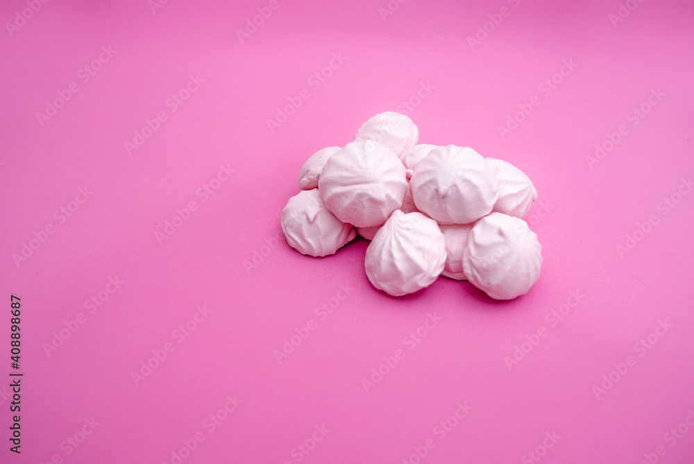 Handful of small marshmallows on a pink background Handful of small marshmallows on a pink background