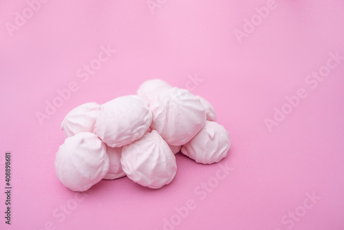 Several small marshmallows on a pink background