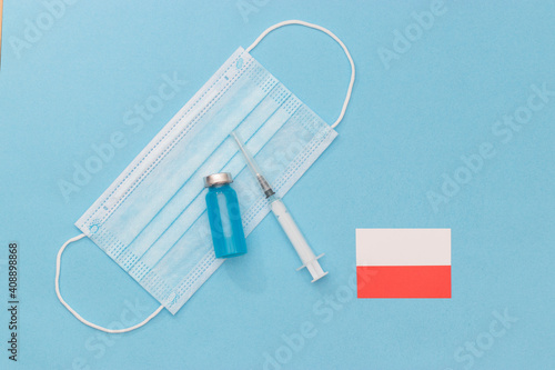 Transparent medical ampoules, stethoscope, syringe and protective mask on a light blue background. medicine, vaccination against covid-19. Protection during a pandemic. vaccination in Poland