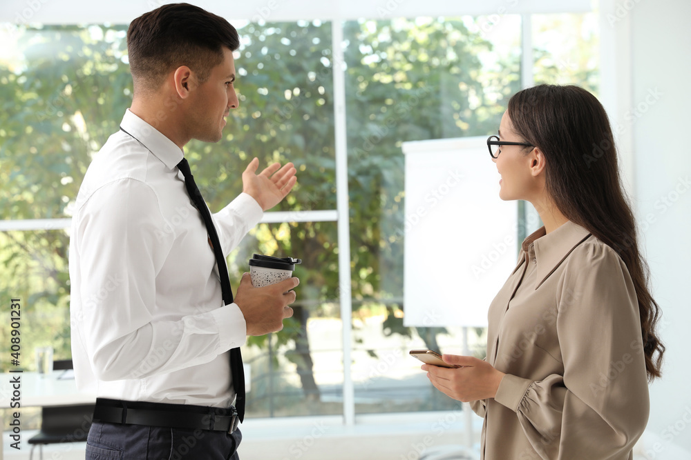 Office employees talking at workplace during break Office employees talking at workplace during break