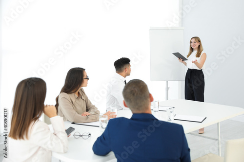 Female business coach talking to audience in office