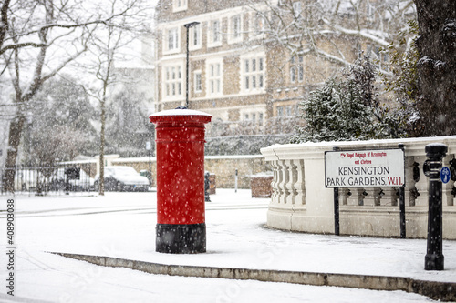 Photography London classic red mailbox  under the falling snow