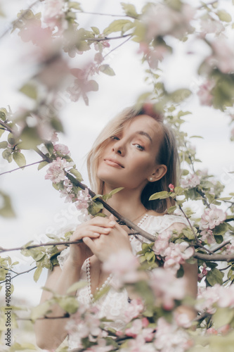 girl in a white dress walks in an apple orchard © alexkazachok