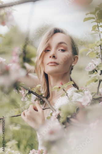 girl in a white dress walks in an apple orchard © alexkazachok