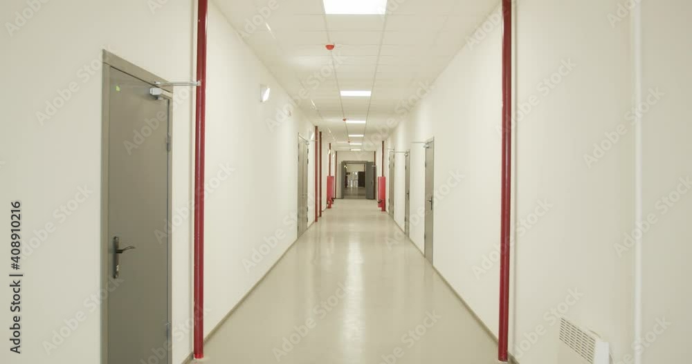 Long corridor with white walls, doors and red pipes on the walls, factory, 4k Long corridor with white walls, doors and red pipes on the walls, factory, 4k