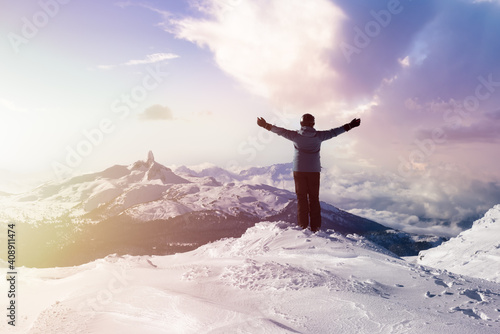 Adventurous Girl on top of a beautiful snowy mountain during a vibrant winter. Hands Up. Sunrise Sky Art Render. Taken in Whistler  British Columbia  Canada.