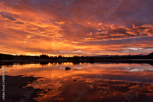 An intense, orange sunset, reflected in Lake Tekapo, Mackenzie District, Canterbury, New Zealand.