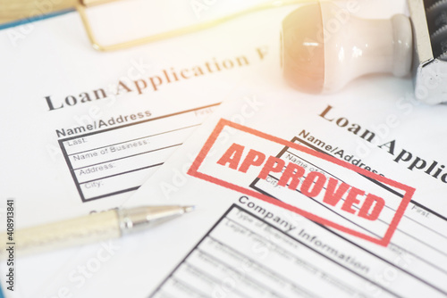 Loan application form with Rubber stamping that says Loan Approved, Financial loan money contract agreement company credit or person loan approval