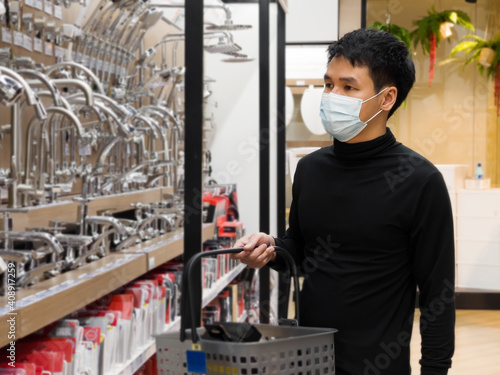 man shopping in department store and his wearing medical mask for prevention coronavirus(covid-19) pandemic
