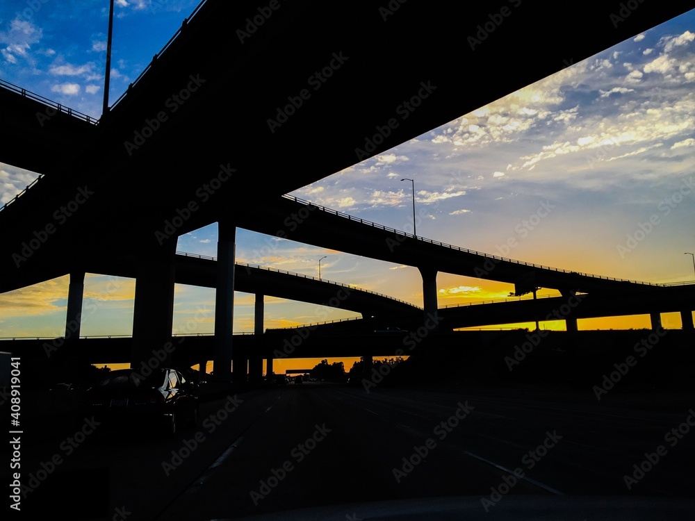 Silhouette of Freeway Highway Interchange ramps  against a sunset cloudy sky in Los Angeles