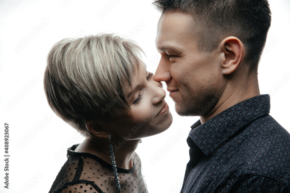 Portrait of a happy fashion couple hugging and kissing each other on an isolated white background. Portrait of a happy fashion couple hugging and kissing each other on an isolated white background.
