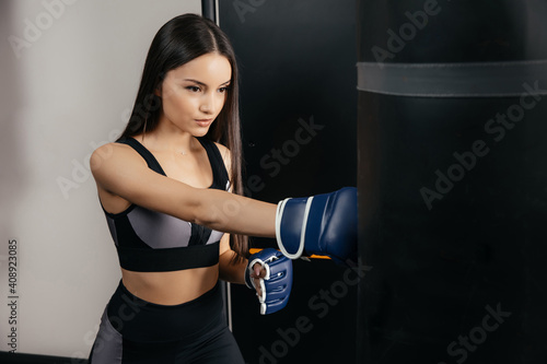 Beautiful 30-year-old woman hits a punching bag. Concept of self-defense and protection. Close-up © Кирилл Горшков