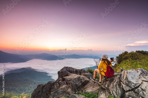 Young girl in yellow jacket hiking on the mountain, Doy-pha-tang, border of Thailand and Laos.