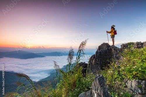 Young girl in yellow jacket hiking on the mountain, Doy-pha-tang, border  of  Thailand and Laos.