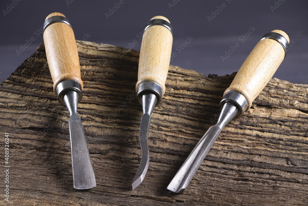 Chisels on a wooden background. Assortment of chisels of wood for carpentry. Set of chisels. A set of tools for wood processing