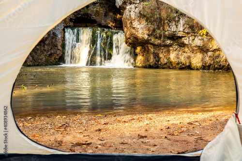 the famous waterfall atysh flowing from a karst funnel in the Ural mountains of Bashkortostan on an autumn sunny day. view from the tent. photo