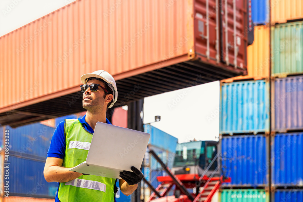 Foreman or Operator Ordering of moving containers with laptop computer. Foreman looking forward on Forklifts in the Industrial Container Cargo freight ship. Foreman or Operator Ordering of moving containers with laptop computer. Foreman looking forward on Forklifts in the Industrial Container Cargo freight ship.